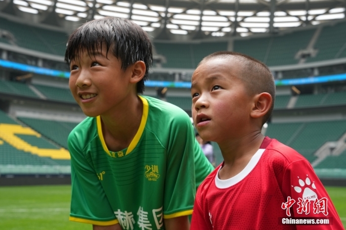 圖為北京國安小球員陳小北和7歲的俄金仁增在一起觀看場內播放的紀錄片。<a target='_blank' href='/' _fcksavedurl='/'><p  align=