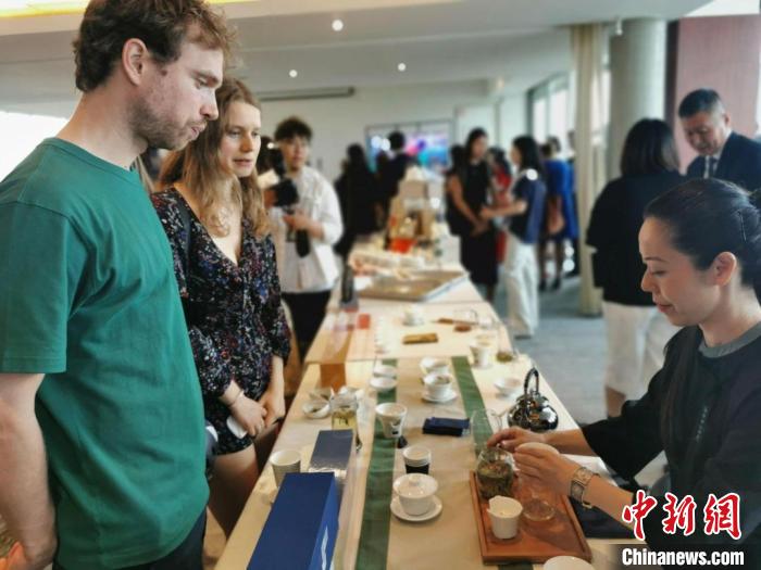 現(xiàn)場(chǎng)觀眾觀看中國(guó)展臺(tái)茶藝表演、了解茶文化。　靖樹(shù) 攝