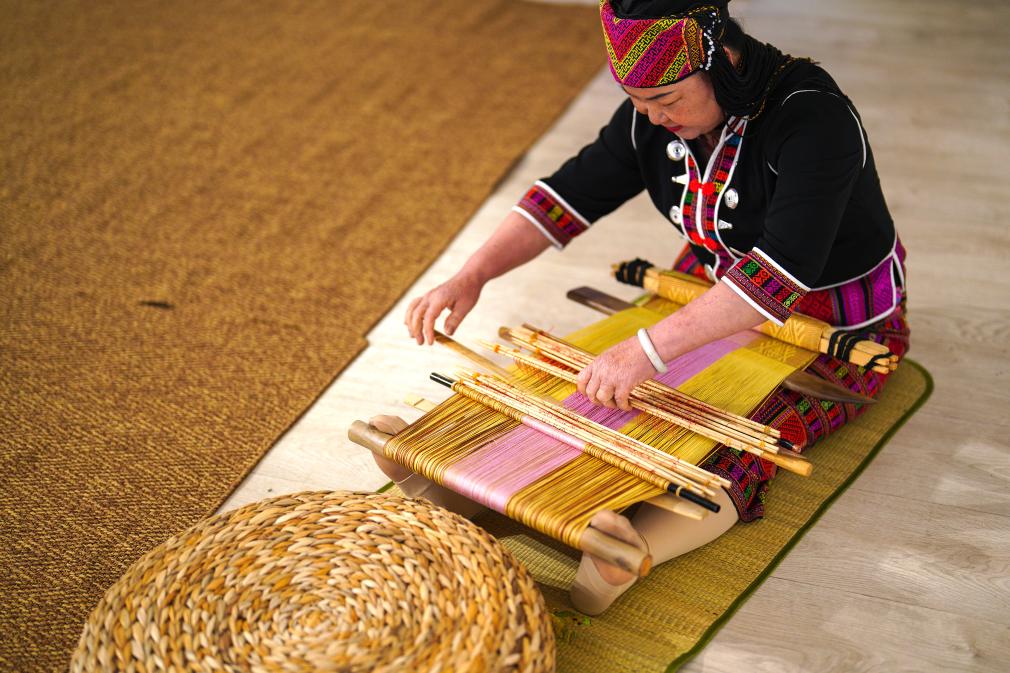 4月17日，黎族傳統(tǒng)紡染織繡技藝國(guó)家級(jí)代表性傳承人劉香蘭在2023年意大利米蘭設(shè)計(jì)周上展示黎錦織造技藝。新華社發(fā)