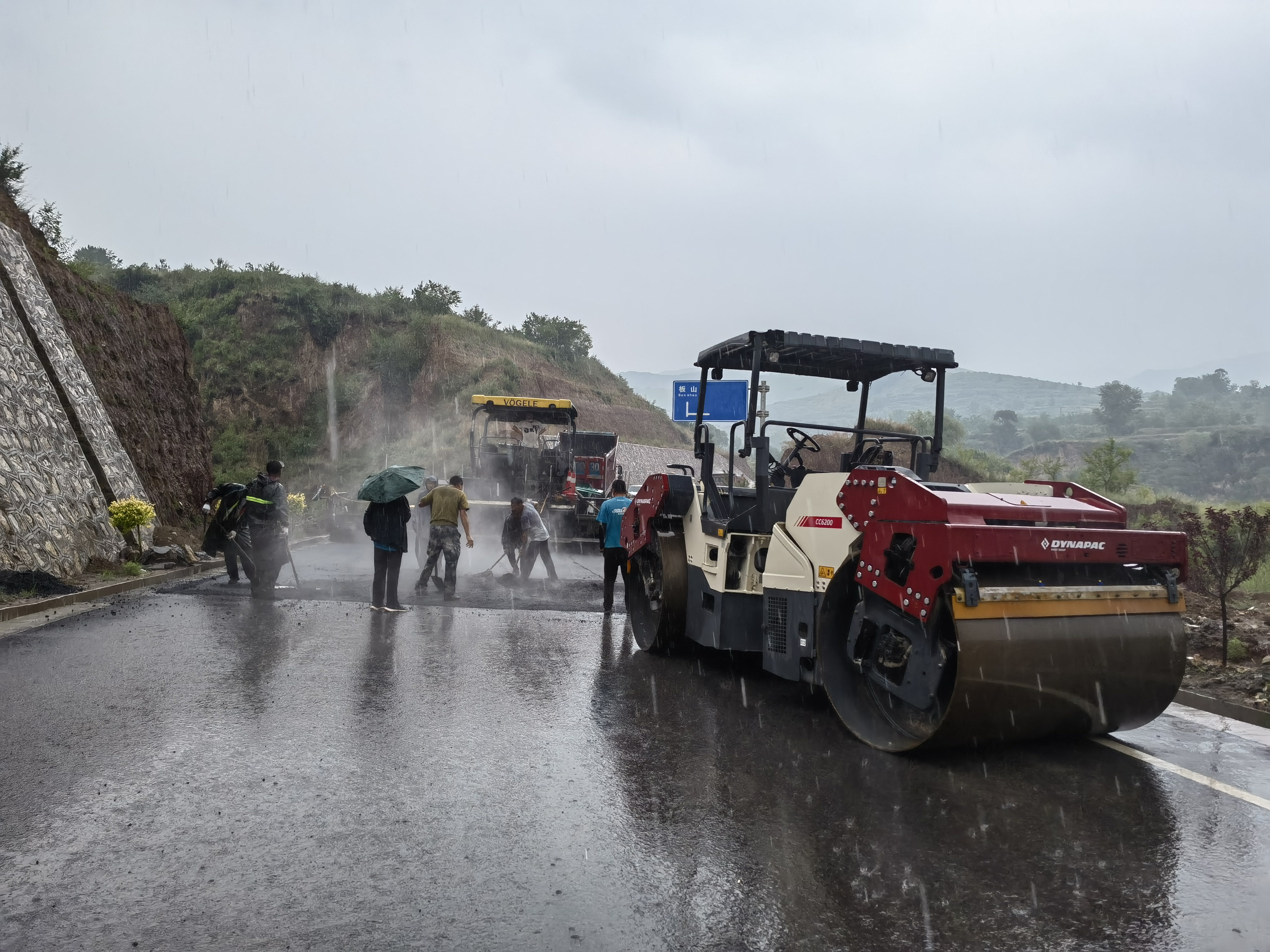 路橋工人在大雨中搶修道路。李華英 攝