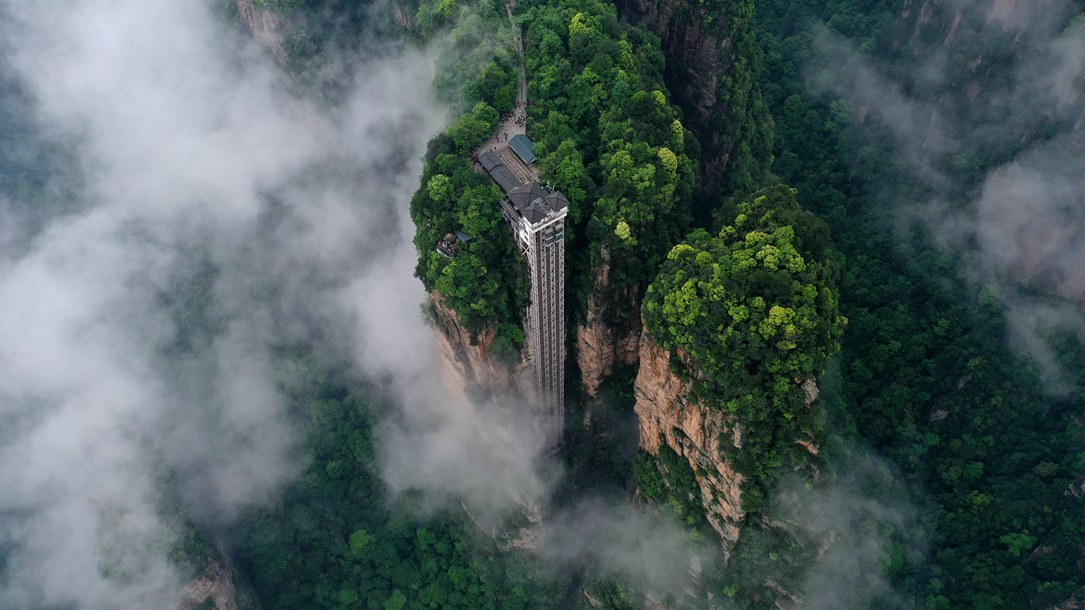 位于張家界武陵源景區(qū)的百龍?zhí)焯蓁偳对谠旗F繚繞的峰林間，雄偉壯觀。吳勇兵攝
