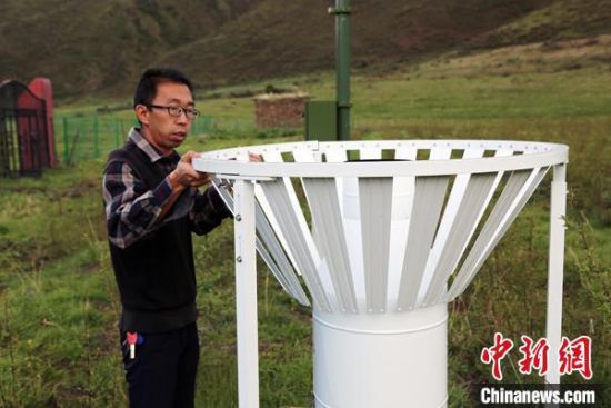 圖為班瑪縣氣象局工作人員在維護藏雪茶基地氣候站。青海省氣象局供圖