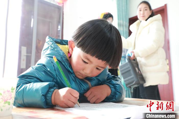 孩子們?cè)诩议T口上學(xué)，是楊周馬草搬入蘭州新家最為開心的事情。小女兒楊洋正在學(xué)習(xí)寫數(shù)字。　魏建軍 攝