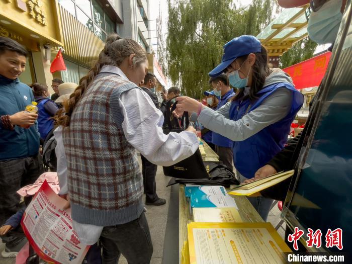 圖為志愿者為市民發(fā)放網(wǎng)絡(luò)安全宣傳手冊?！≈x牧 攝
