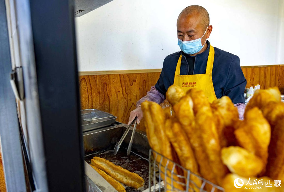 早餐店老板正在炸油條。人民網(wǎng) 次仁羅布攝