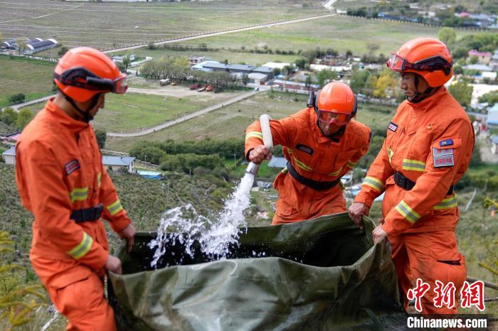 技能大練兵過程中，消防員在陡坡上向蓄水池注水?！±顕鵂c 攝