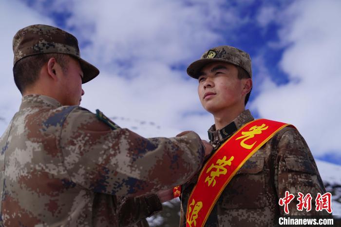 排長(zhǎng)王朝偉(圖左)給退伍老兵佩戴大紅花。　西藏山南軍分區(qū)某團(tuán)供圖