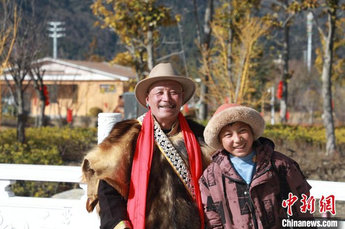 圖為林芝市巴宜區(qū)布久鄉(xiāng)仲果村村民桑杰與孫子一起參加藏歷新年活動?！埩?攝